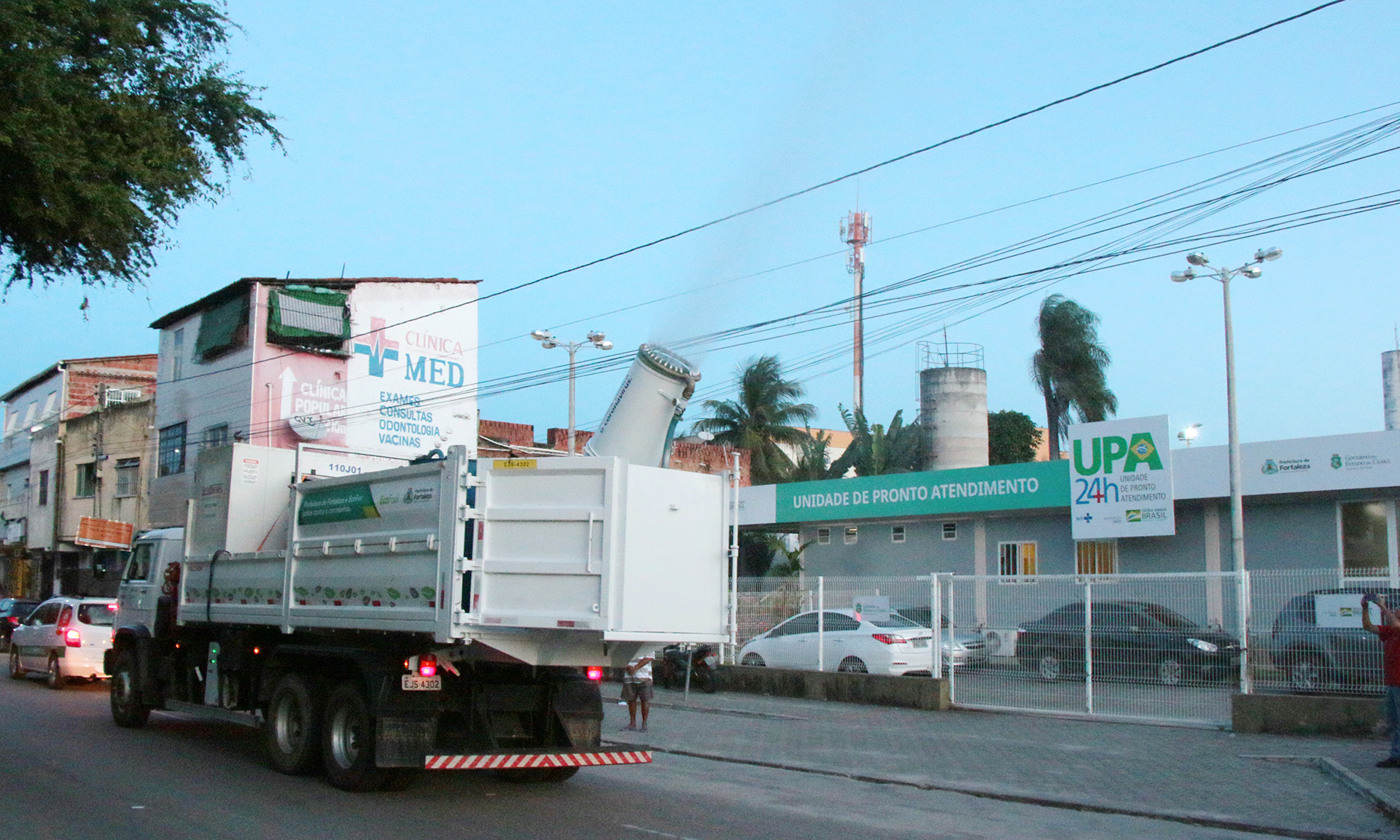 caminhão pulverizando produto em frente a UPA
